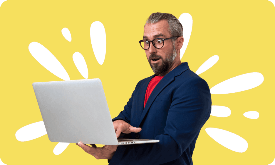 surprised-looking man wearing glasses and a suit holding the open laptop in his hands